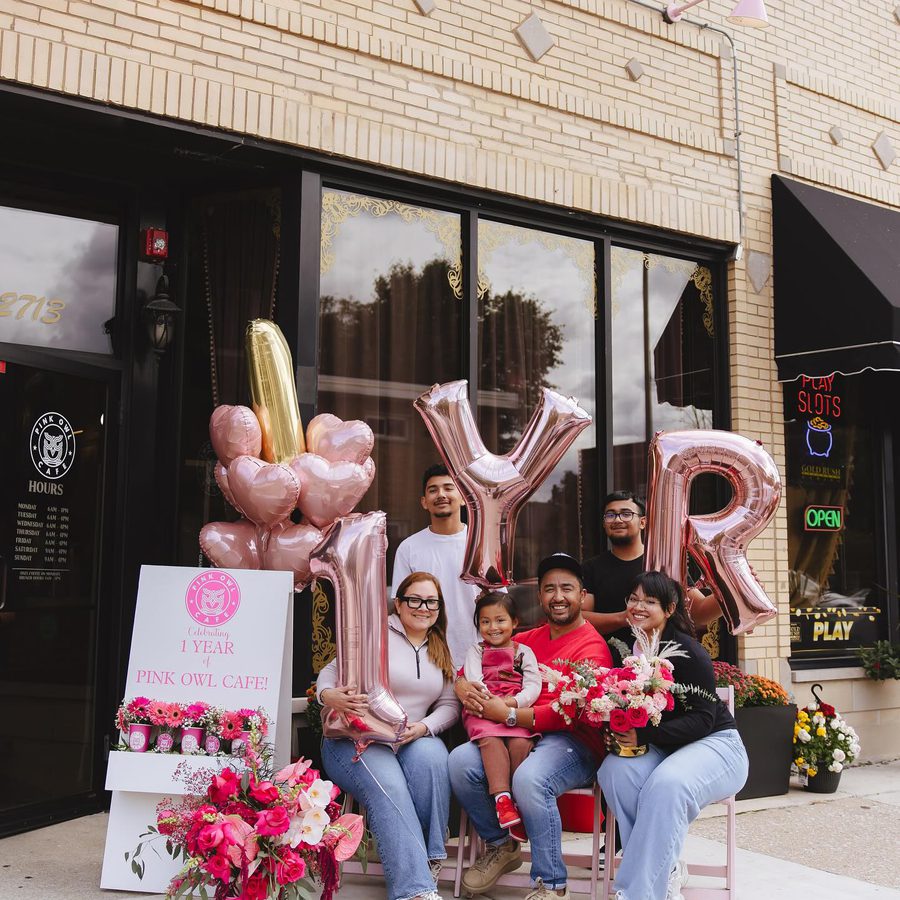 Alex and his family outside the cafe with 1YR balloons and flowers